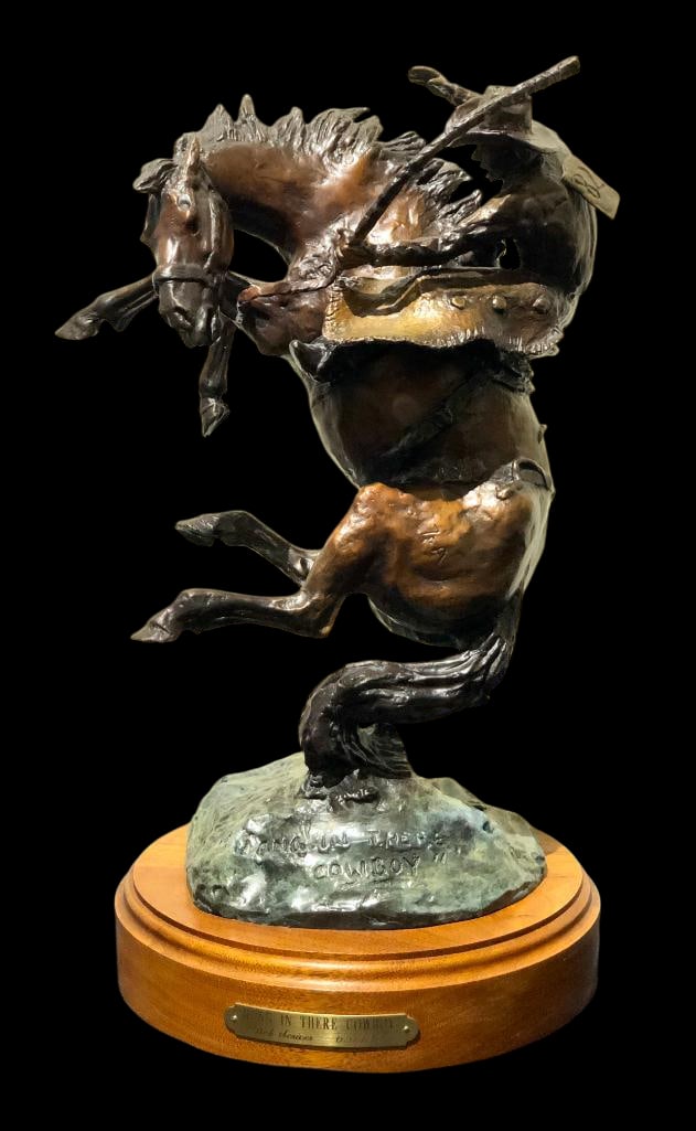 “Hang In There Cowboy?? A Bronze By Bob Scriver: Offered here for your consideration is a bronze titled Hang In There Cowboy by Bob Scriver. This sculpture features a cowboy on a bucking horse and is mounted on a wood base. The bronze is signed and