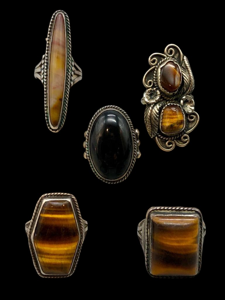 Group Of Tigers Eye, Onyx And Petrified Wood Sterling Silver Rings: Offered here for your consideration is a group of five sterling silver rings featuring tigers eye, onyx and petrified wood stones. Each ring features a cabochon set in a silver bezel framed with twist