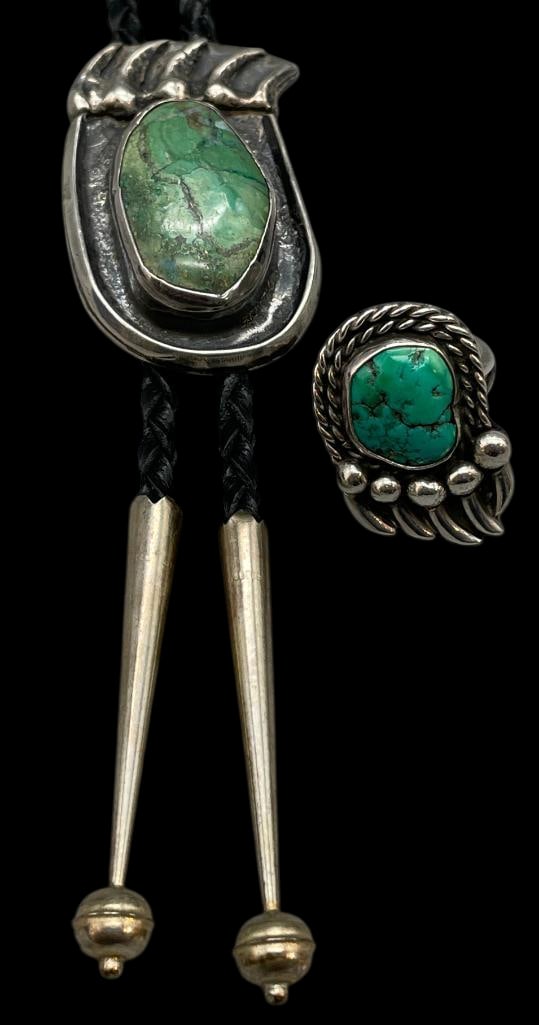 Sterling Silver And Turquoise Bear Paw Theme Bolo Tie And Ring: Available here in this lot is a sterling silver and turquoise bear paw theme bolo tie and ring. Both pieces feature a bear paw design highlighted with a turquoise cabochon set in a smooth silver