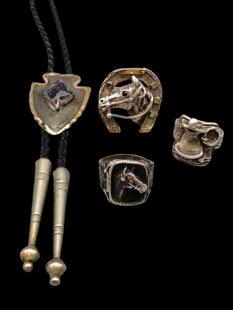 Three Sterling Silver Rings And Sterling Silver Bolo Tie: Offered here for your consideration are three sterling silver rings and a sterling silver bolo tie. The rings showcase western themed designs including one with a horseshoe and others with saddle and