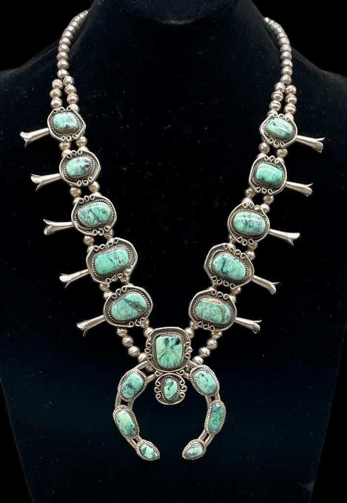Vintage Sterling Silver And Green Stone Squash Blossom Necklace: Offered here for your consideration is a vintage sterling silver and green stone squash blossom necklace. The two wire naja features eight green stone cabochons set in smooth silver bezels. Accenting