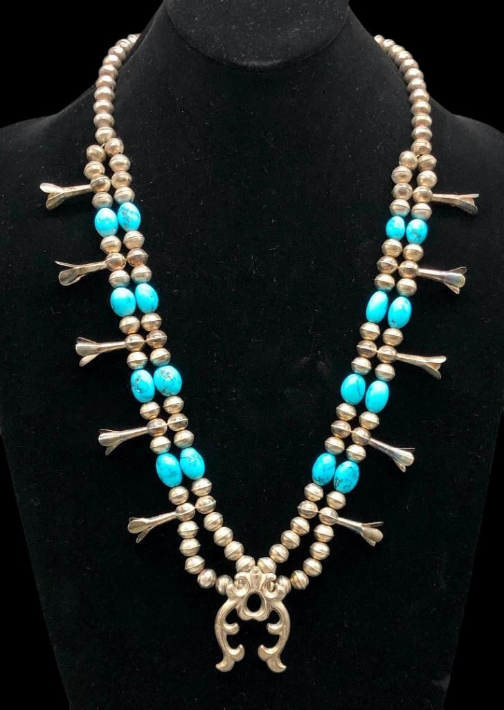 Turquoise And Sterling Silver Naja And Blossom Necklace: Offered here for your consideration is a turquoise and sterling silver naja and blossom necklace. The necklace showcases a cast silver naja with intricate designs. Along the neckline are 10 blossoms. 