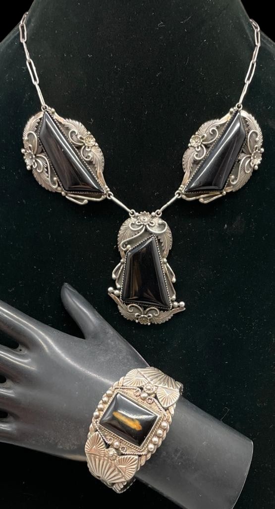 Sterling Silver And Onyx Necklace With Bracelet: Offered here are a sterling silver and onyx necklace with bracelet. This necklace is highlighted with three pendants each highlighted with an onyx cabochon set in sawtooth silver bezels surrounded by 