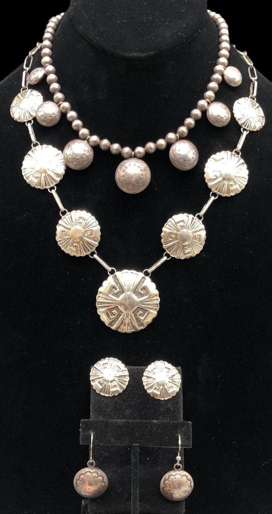 Two Sterling Silver Necklaces With Matching Earrings: Offered here are two sterling silver necklaces with matching earrings. The first set features pendants and earrings with nicely shaped edges and hand stamped patterns. The pendants are in graduated si