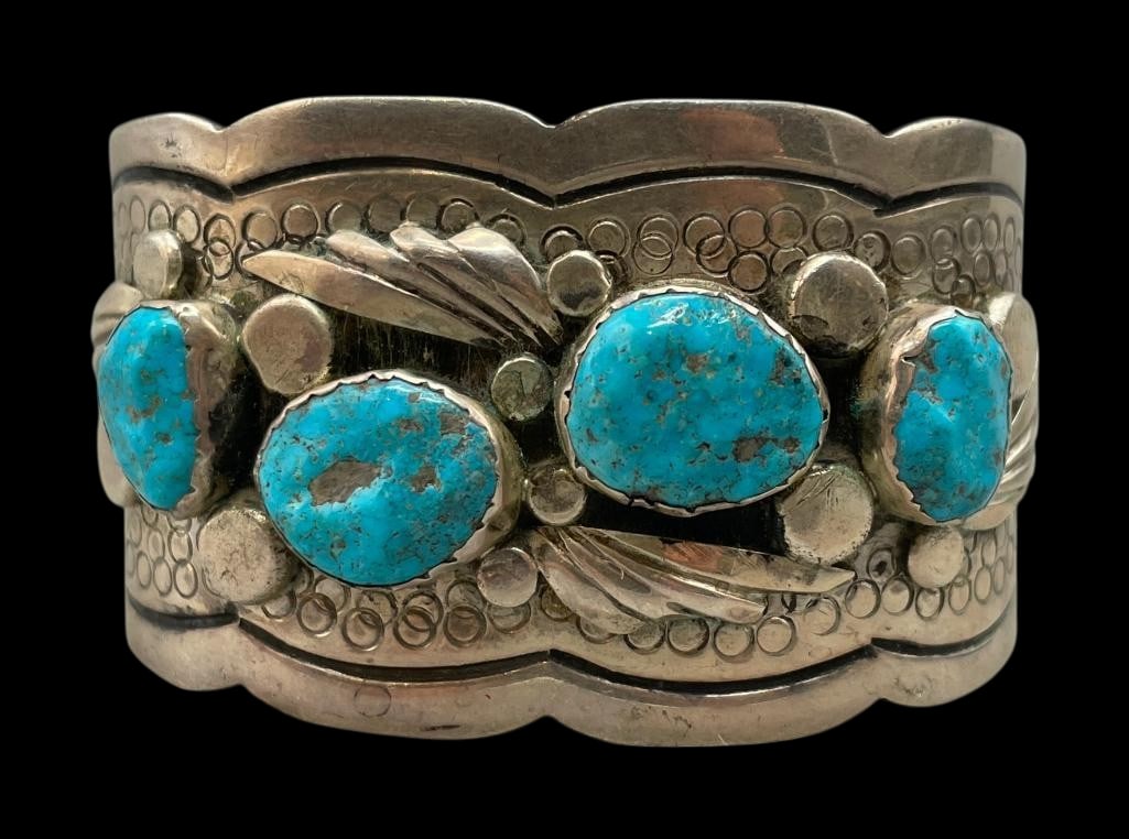 Four Stone Sterling Silver And Turquoise Bracelet: Offered here for your consideration is a four stone sterling silver and turquoise bracelet. This piece features four turquoise cabochons set in scalloped silver bezels. Accenting the stones are feathe