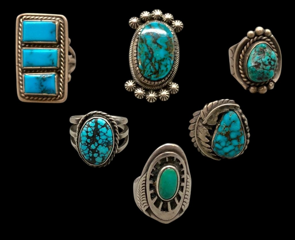Six Sterling Silver And Turquoise Rings: Offered here are six sterling silver and turquoise rings. These pieces are each highlighted turquoise cabochons set in silver bezels. Accenting the stones is silver work of twisted wires, silver
