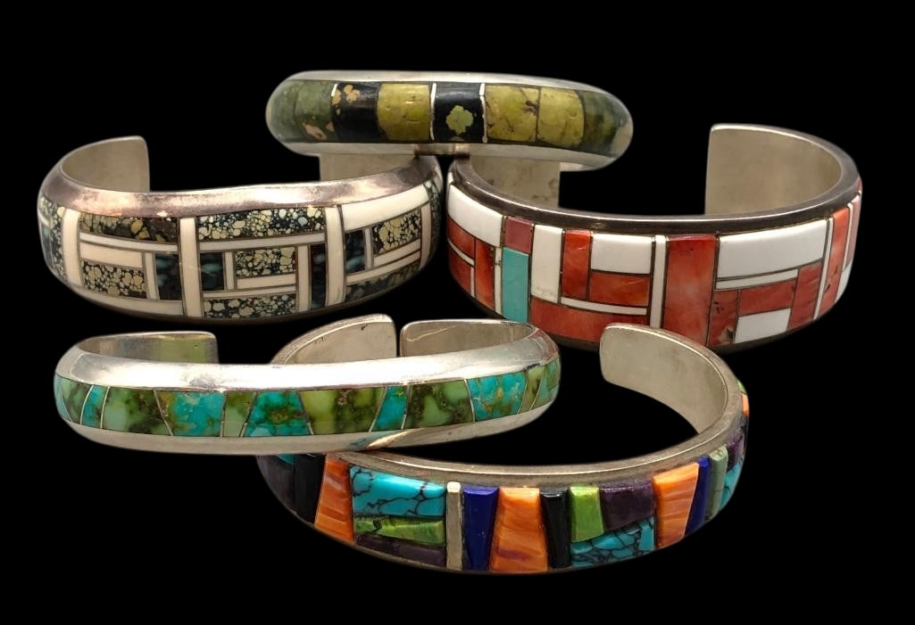 Five Sterling Silver Inlay Bracelets: Available here in this lot are five sterling silver inlay bracelets. Each piece features a multi stone channel, cobblestone or flush inlay design. The stones include coral, turquoise, lapis, spiny oys