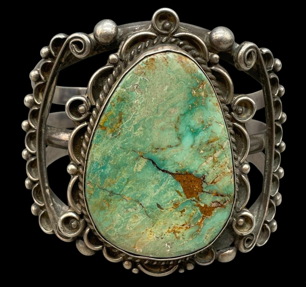 Turquoise And Sterling Silver Bracelet: For your bidding enjoyment we present a turquoise and sterling silver bracelet. This bracelet features a turquoise cabochon set in a smooth silver bezel. Surrounding the stone are twisted wires, silve