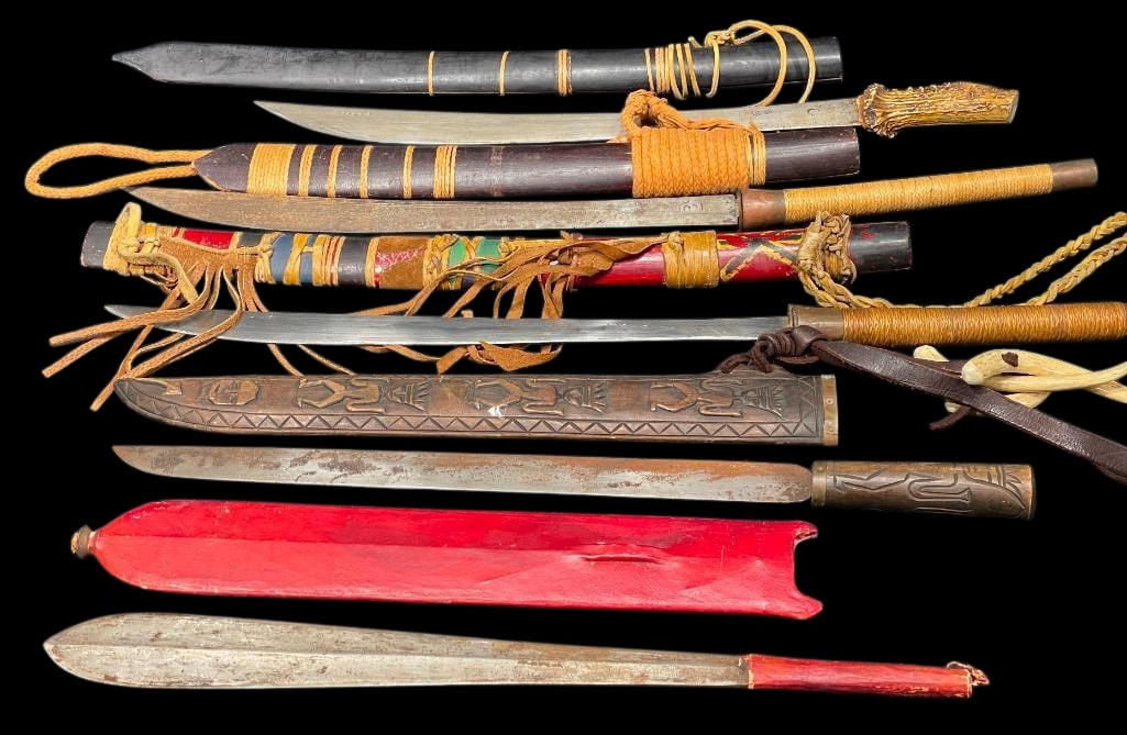 Group of Five Machetes Exotic In Style: Offered here for your consideration is a group of five machetes, all of which are exotic in style. They feature single edged steel blades, some highlighted with etched symbols. The machetes have