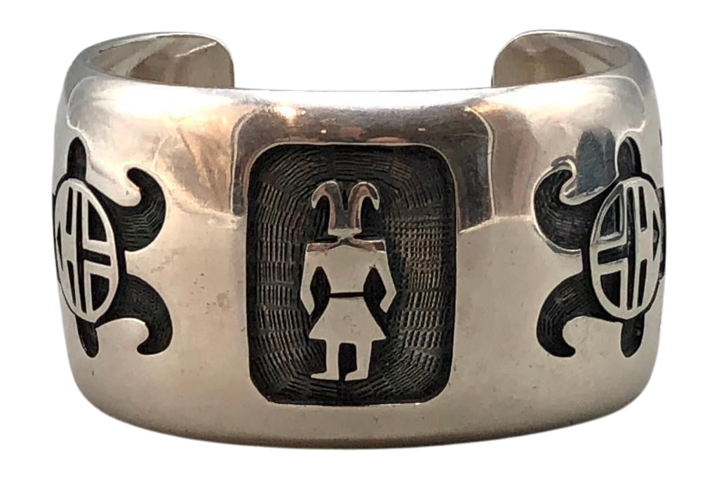 Bernard Dawahoya Sterling Silver and Overlay Bracelet: Offered here for your consideration is a Bernard Dawahoya sterling silver and overlay bracelet. This piece features a Kachina themed overlay designs on an etched and darkened silver background. The br