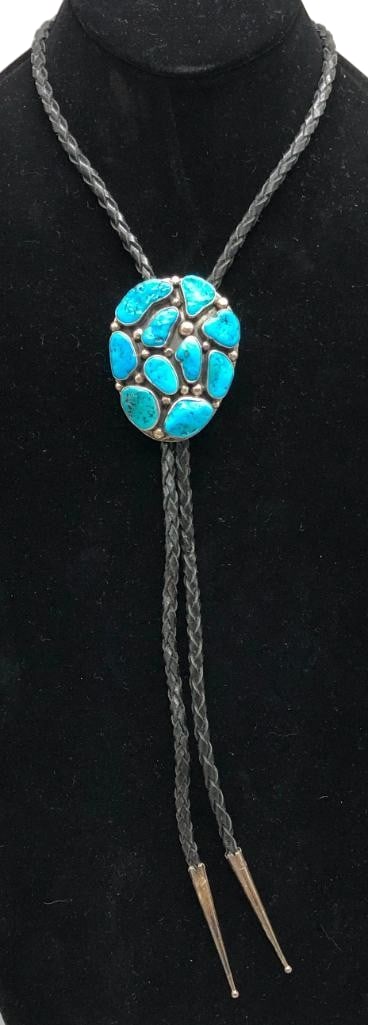Sterling Silver And Turquoise Cluster Bolo Tie By Navajo Guild: Offered here for your consideration is a sterling silver and turquoise cluster bolo tie by Navajo Guild. The slide features a cluster of turquoise cabochons set in smooth silver bezels accented with s