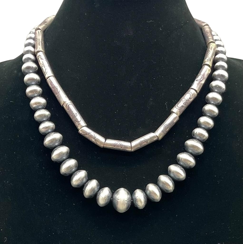 Two Sterling Silver Bead Necklaces: Offered here for your consideration are two sterling silver bead necklaces. These pieces feature a strand of round or tube sterling silver beads accented with hand stamped designs. The beads are strun