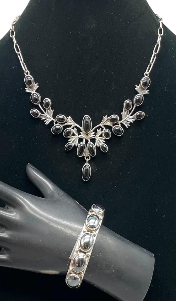 Sterling Silver And Hematite Bracelet With Sterling Silver And Onyx Necklace: Offered here are a sterling silver and onyx necklace and sterling silver and hematite bracelet. This necklace features three pendents highlighting onyx stones set in smooth silver bezels with leaf lik