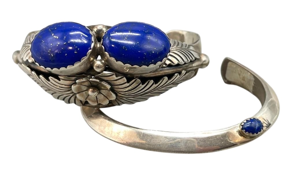 Two Sterling Silver And Lapis Bracelets: Available here for your consideration are two sterling silver and lapis bracelets. The first bracelet features two lapis cabochons set in sawtooth bezel accented by silver dots, floral motifs and hand