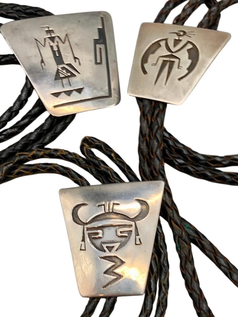 Three Sterling Silver Bolos By Willie Yazzie, Sr.: Available here for your consideration are three sterling silver bolos by Willie Yazzie, Sr.. These bolo slides showcase overlay designs featuring figures, birds and other motifs, highlighted by near p