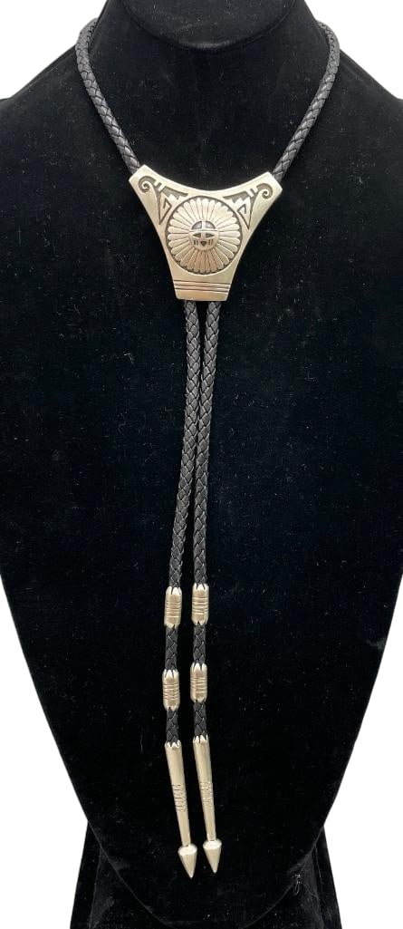 Nice Sterling Silver Sunface Bolo Tie: Offered here for your consideration is a nice sterling silver Sunface bolo tie. The slide features a Sunface themed overlay design on a darkened silver background. It is on a thick black braided leath
