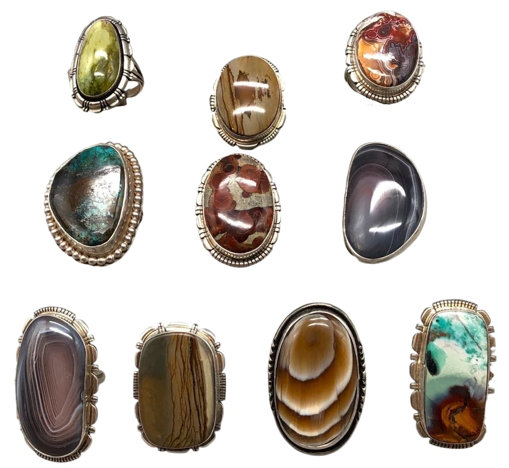 Group Of 10 Sterling Silver Rings With Various Settings: Offered here are a group of 10 sterling silver rings with various settings. These pieces showcase a variety of stones set in silver bezels. They are accented with silver dots, darkened background and 