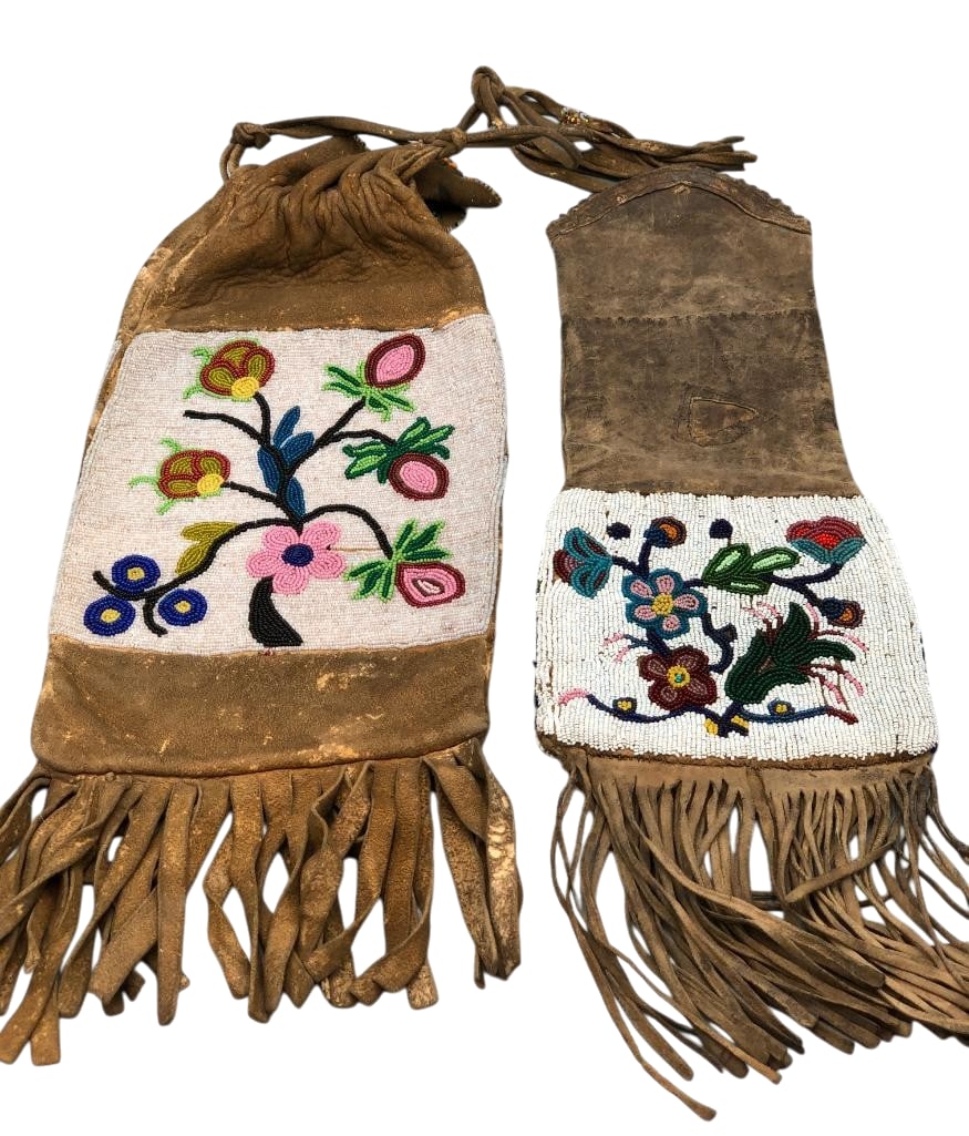 Woodlands Beaded Pipe Bags: Offered here for your consideration are two Woodlands beaded pipe bags. They feature floral beadwork done in colors of white, blue, pink, green, yellow, red and others sewn on brain tanned leather hid