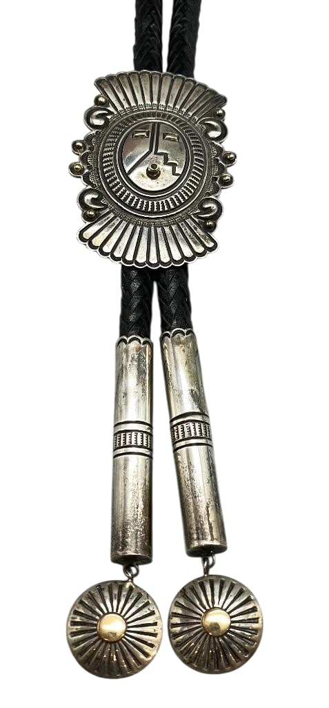 Edison Cummings Sterling Silver And Gold Bolo Tie: Offered in this lot is an Edison Cummings sterling silver and gold bolo tie. This slide features an intricate face like motif adorned with hand stamped designs, repousse work and marked 14K gold accen