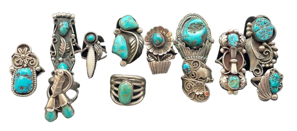Group Of 12 Silver And Turquoise Rings: Offered here is a group of 12 silver and turquoise rings. These pieces are highlighted with a variety of silver designs with turquoise cabochons. Patterns include blossoms, flower pot, leaves and more