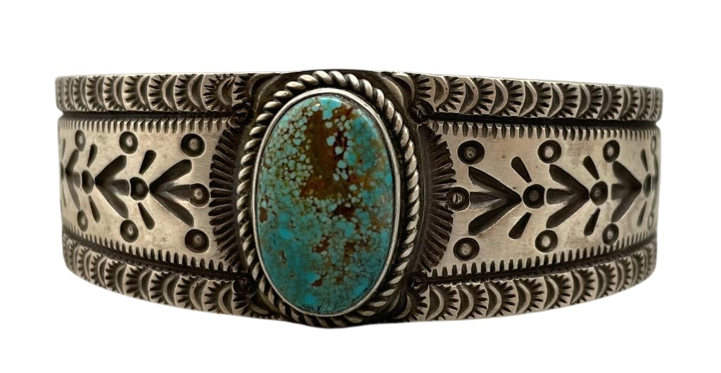 Herman Smith Sterling Silver And Turquoise Bracelet: For your bidding enjoyment we present a Herman Smith sterling silver and turquoise bracelet. This piece features a central turquoise cabochon set in a smooth silver bezel. Surrounding the stone is a t