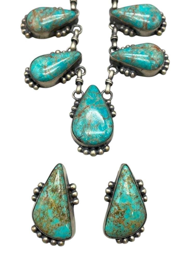 Sterling Silver And Turquoise Necklace Set By Julia Etsitty: Offered here is a sterling silver and turquoise necklace and earring set by Julia Etsitty. This necklace features nine pendants each highlighted with a turquoise cabochon set in a smooth silver bezel.
