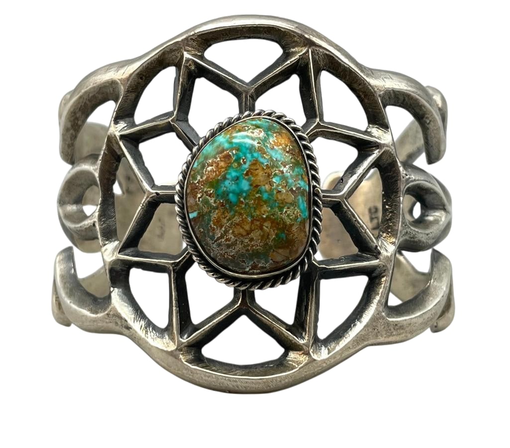 Sterling Silver And Turquoise Sandcast Bracelet by LTC: For your bidding enjoyment we present a sterling silver and turquoise sandcast bracelet by LTC. This bracelet features a central turquoise cabochon set in a smooth silver bezel. Surrounding the stone 