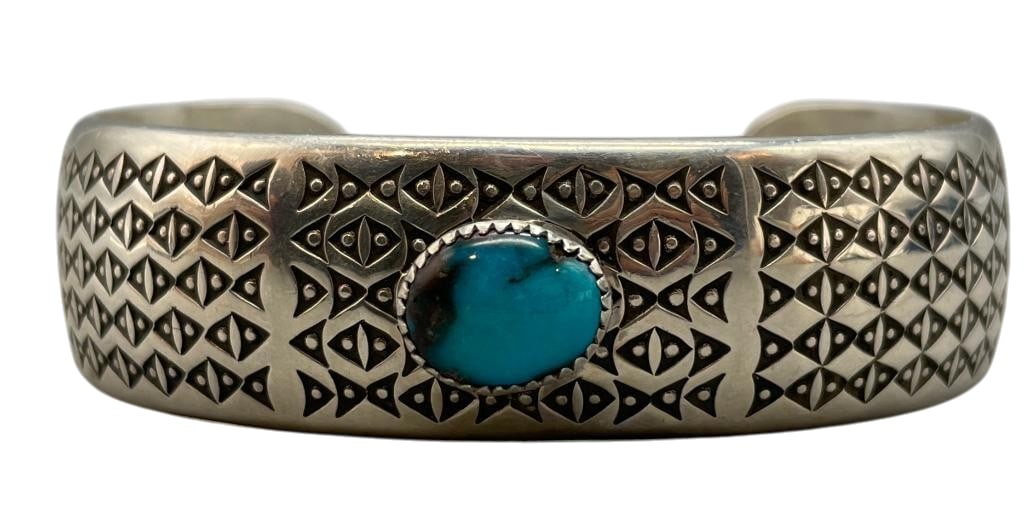 Sterling Silver And Bisbee Turquoise Stamped Cuff Bracelet By Norbert Peshlakai: For your bidding enjoyment we present a sterling silver and Bisbee turquoise stamped cuff bracelet by multiple award winning artist Norbert Peshlakai. This bracelet features a Bisbee turquoise cabocho