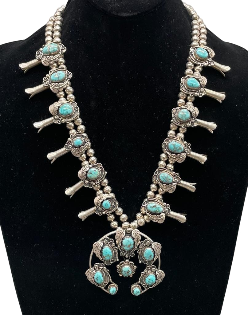 Vintage Sterling Silver And Turquoise Squash Blossom Necklace: Offered here for your consideration is a vintage sterling silver and turquoise squash blossom necklace. This necklace features a two wire naja highlighted with seven turquoise cabochons in graduated s