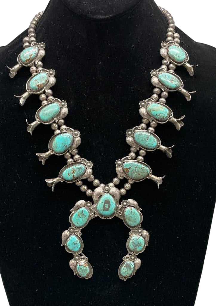 Vintage 17 Stone Turquoise and Sterling Silver Squash Blossom Necklace: Offered here is a vintage 17 stone turquoise and sterling silver squash blossom necklace. This pendant features a three wire naja highlighted with seven turquoise cabochons set in smooth silver bezels