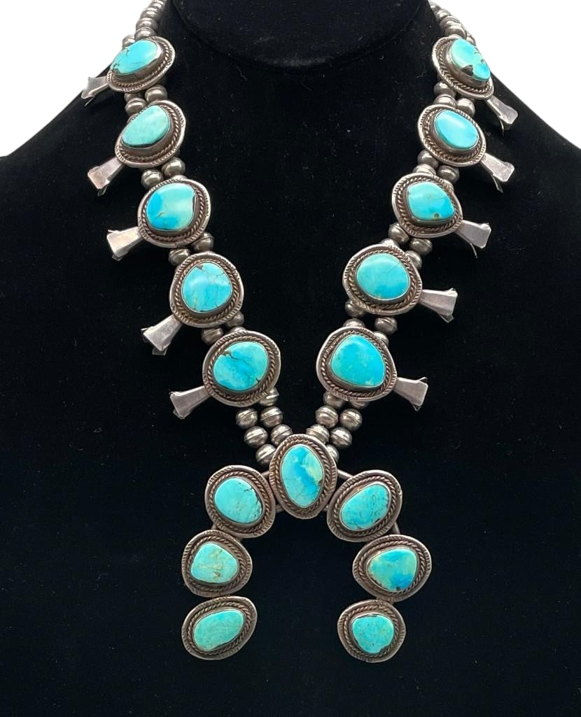 Vintage Turquoise And Sterling Silver Squash Blossom Necklace: Offered here for your consideration is a vintage turquoise and sterling silver squash blossom necklace. This necklace features a two wire naja highlighted with seven turquoise cabochons all set in smo