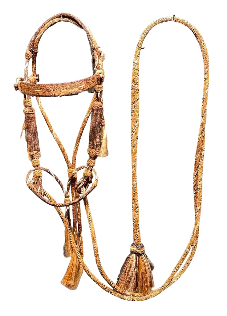 Contemporary Deer Lodge Hitched Horsehair Headstall and Reins: Offered here for your consideration is a contemporary Deer Lodge hitched horsehair headstall and reins. The hitched horsehair headstall features black, white and tan designs with horsehair tassels. It