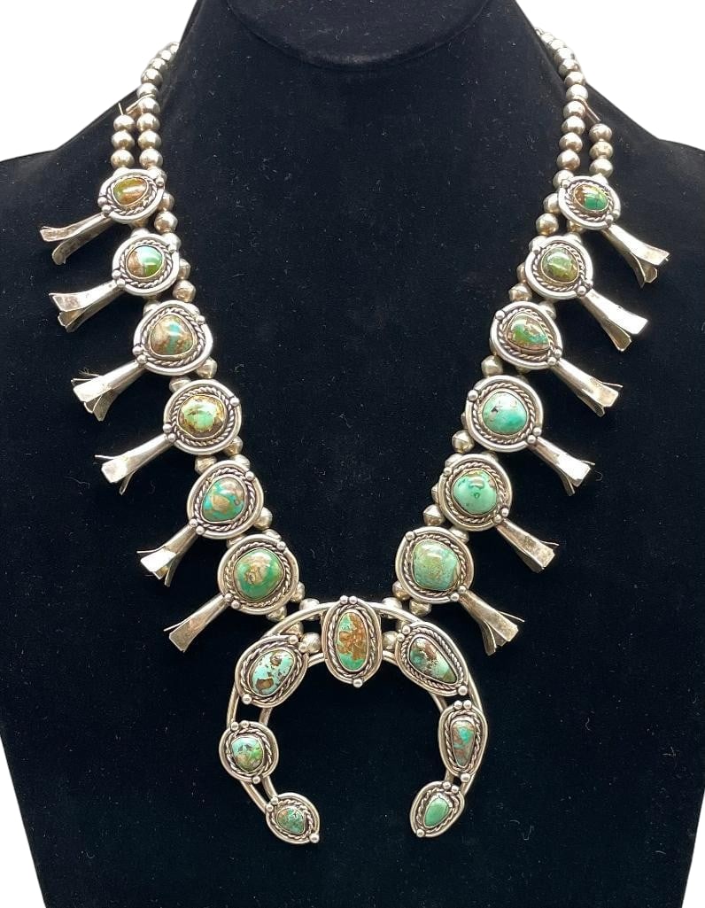 Nice Green Turquoise And Sterling Squash Blossom Necklace With 4 Petal Blossoms, Circa 1960s-1970s: Offered here for your consideration is a nice green turquoise and sterling silver squash blossom necklace with four petal blossoms, circa 1960s-1970s. This necklace features a two wire naja highlighte