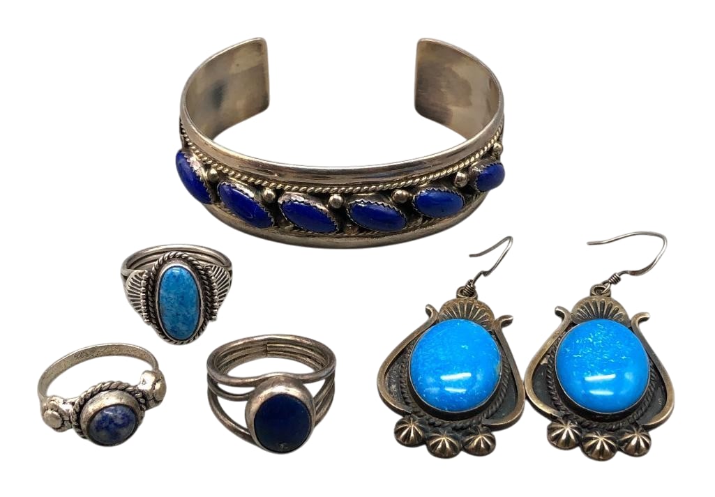 Sterling Silver And Lapis Jewelry Group: Offered here for your consideration is a group of sterling silver and lapis jewelry including three rings, a solid cuff bracelet and one pair of earrings. Each of the pieces feature lapis cabochons se