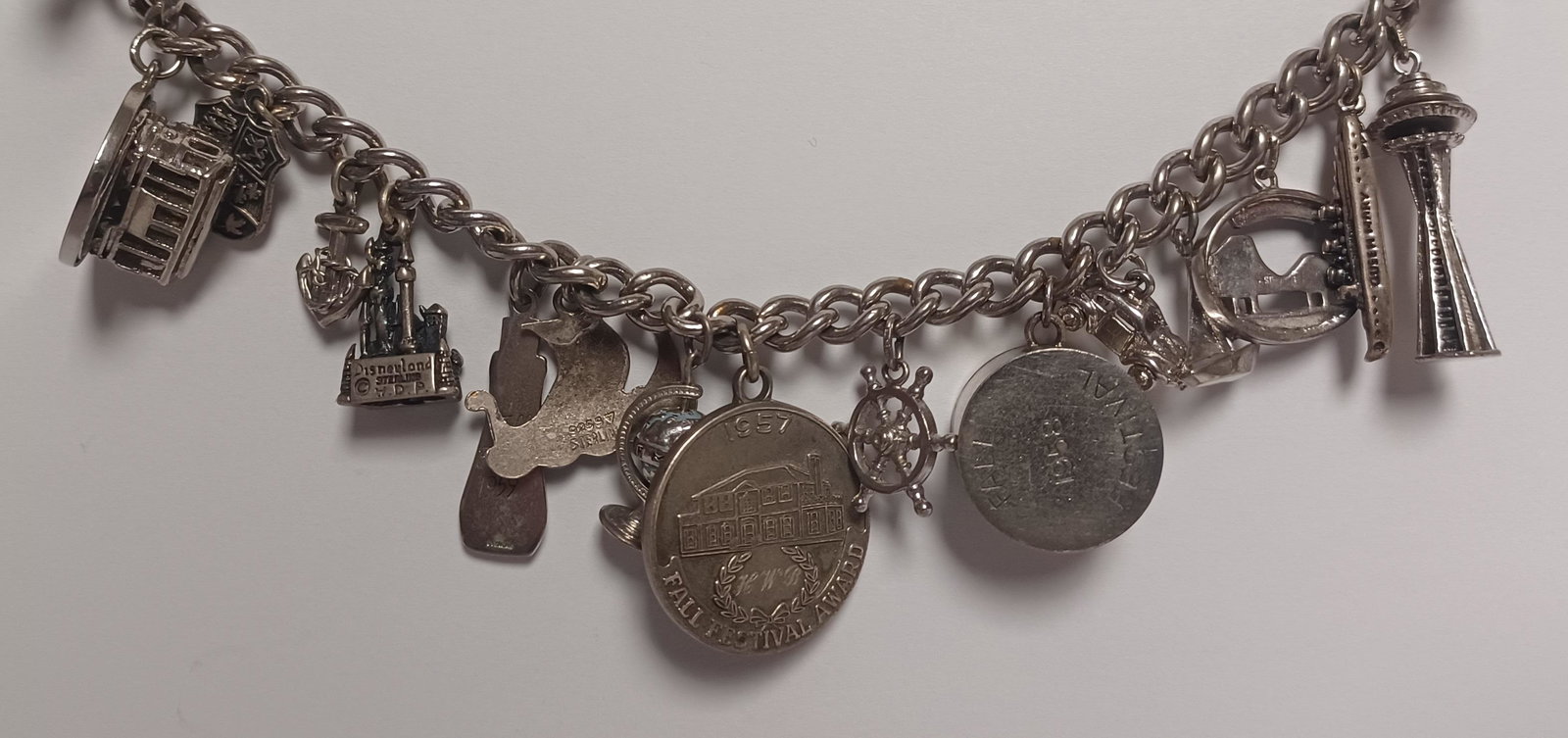 Vintage Memory Charm Bracelet With Sterling Charms: Vintage Memory Charm Bracelet With Sterling Charms. 7 Of the Charms are marked as Sterling, Bracelet we do not believe is silver. Bracelet Measures 6.5 "