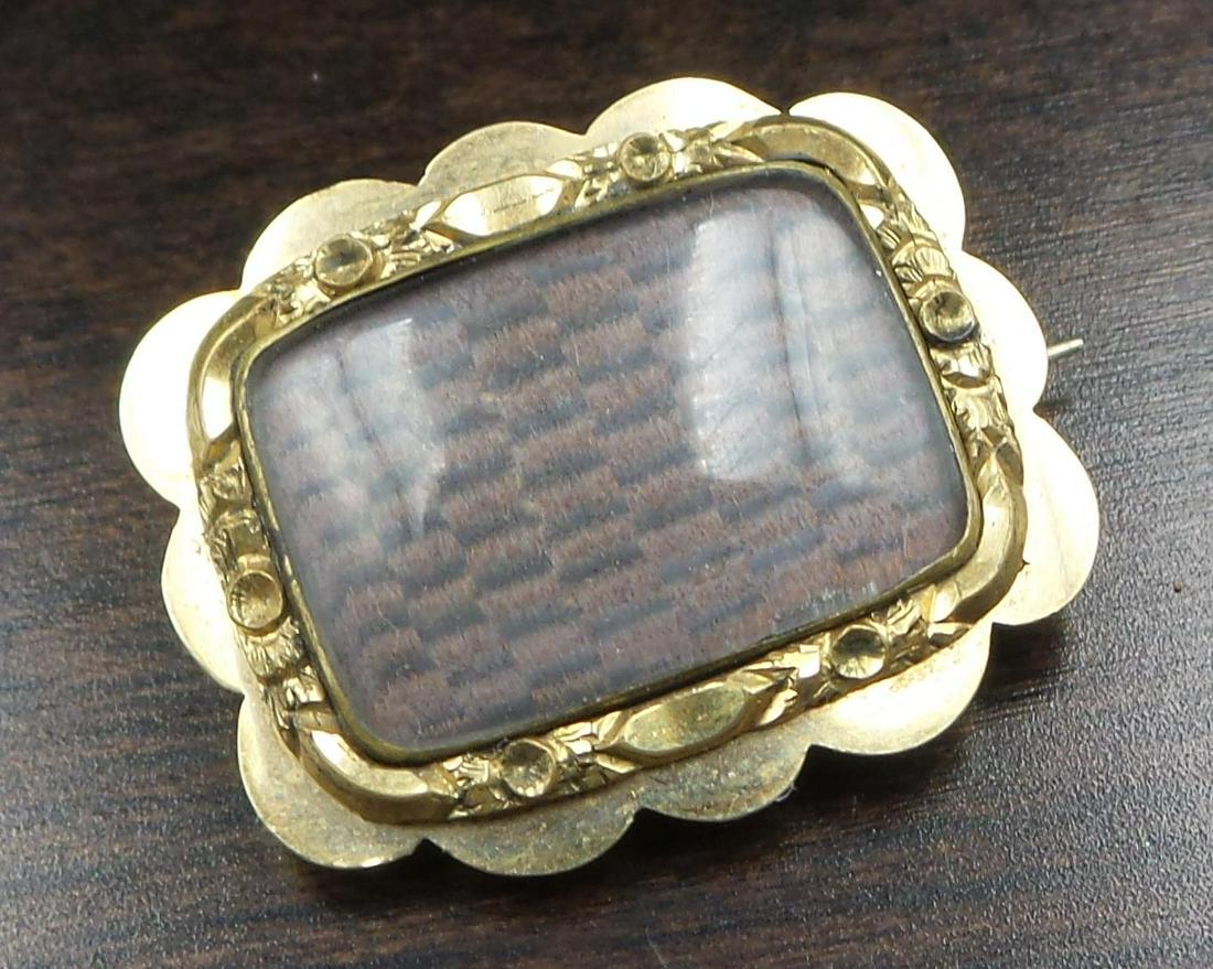 Antique Victorian 9K Yellow Gold Mourning Jewelry Brooch /w French Hair Art: A stylish antique mourning/sentimental locket front brooch. Crafted in solid 9K gold, the brooch features a glass compartment containing plaited blond and brown hair, in memory of a beloved person lon