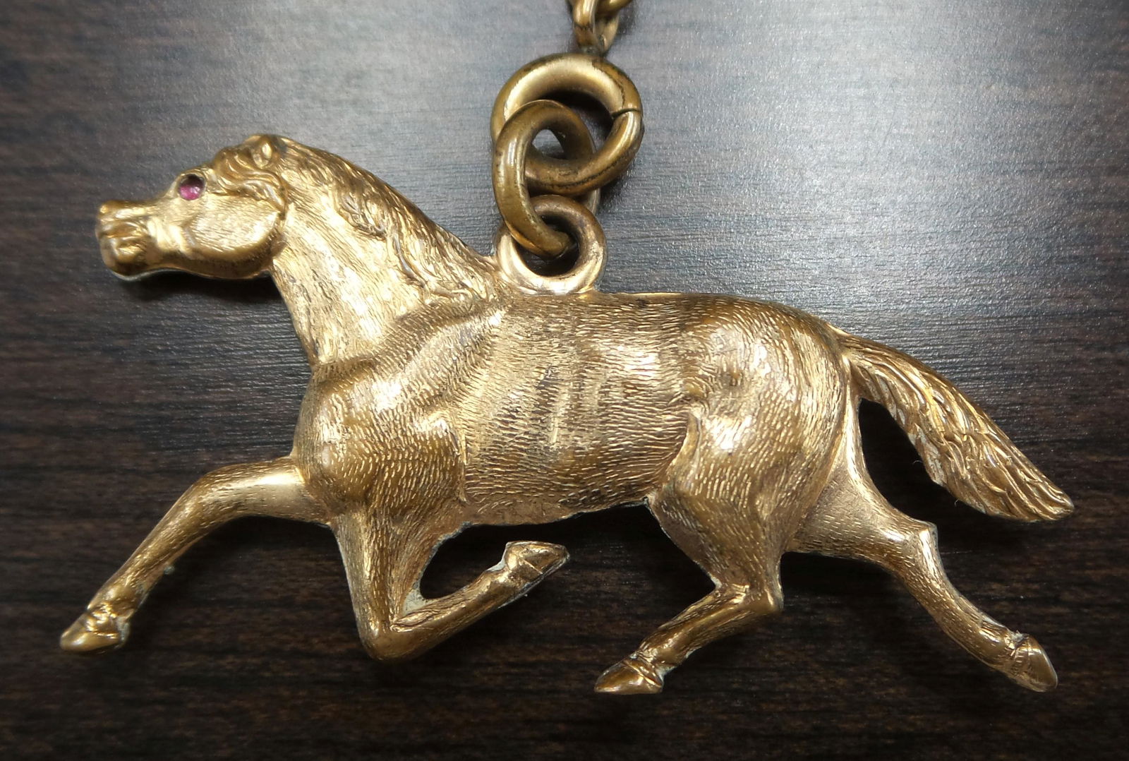 Rare Antique 1900s Gold Plated Pocket Watch Chain /w Ruby Eye Horse Fob: Rare equestrian piece. Measures approx. 16" long (chain) / 1 5/8" long x 3/4" high (horse) and weighs ca. 13.7 grams. Good antique condition with only minor wear to gilding and no missing pieces.