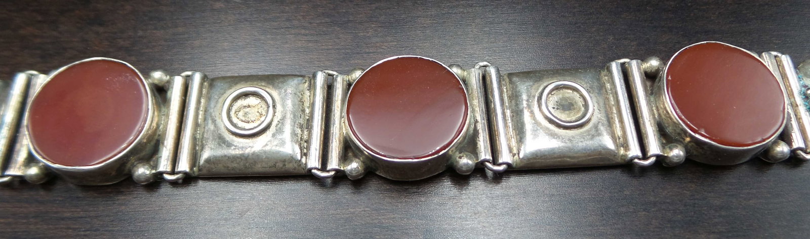 Antique Oriental Sterling Silver & Carnelian Panel Bracelet: Beautifully hand crafted piece from around 1910. Features 4 red Carnelian gemstone discs collar set between stylish panel elements. Very good antique condition with some patina according to age which 
