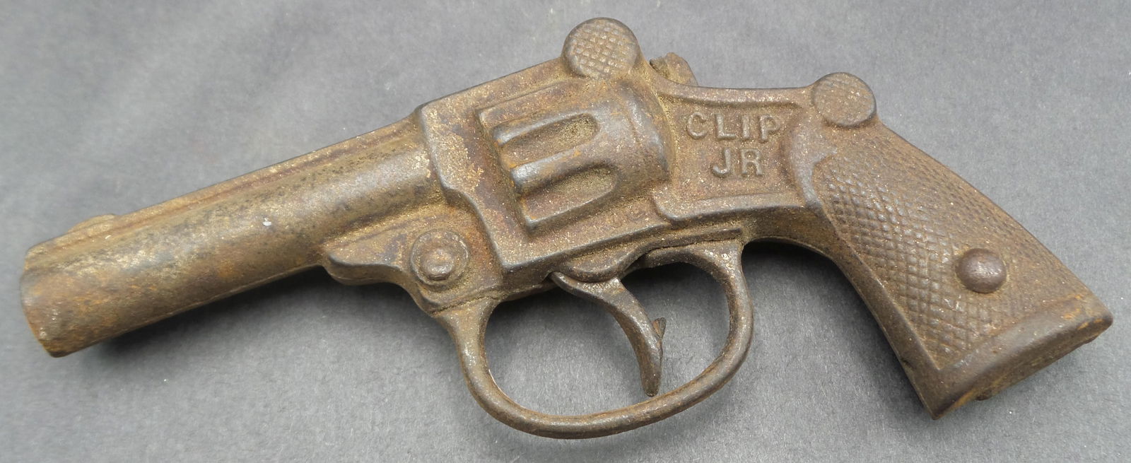 Antique 1935 STEVENS CLIP JR Cast Iron Cap Gun Toy: Good condition with wear and some surface corrosion according to age. Broken hammer and missing spring. Measures approx. 5" long.