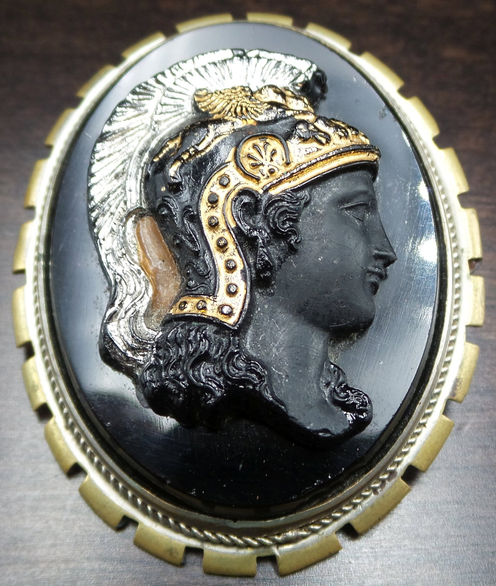 Antique ca. 1910 European Costume Jewelry Black Cameo Brooch: This gorgeous piece was made around the 1910s in Europe showcasing an amazing level of craftmanship. It features the gold painted head of a female goddess or warrior made from an unidentified heavy bl
