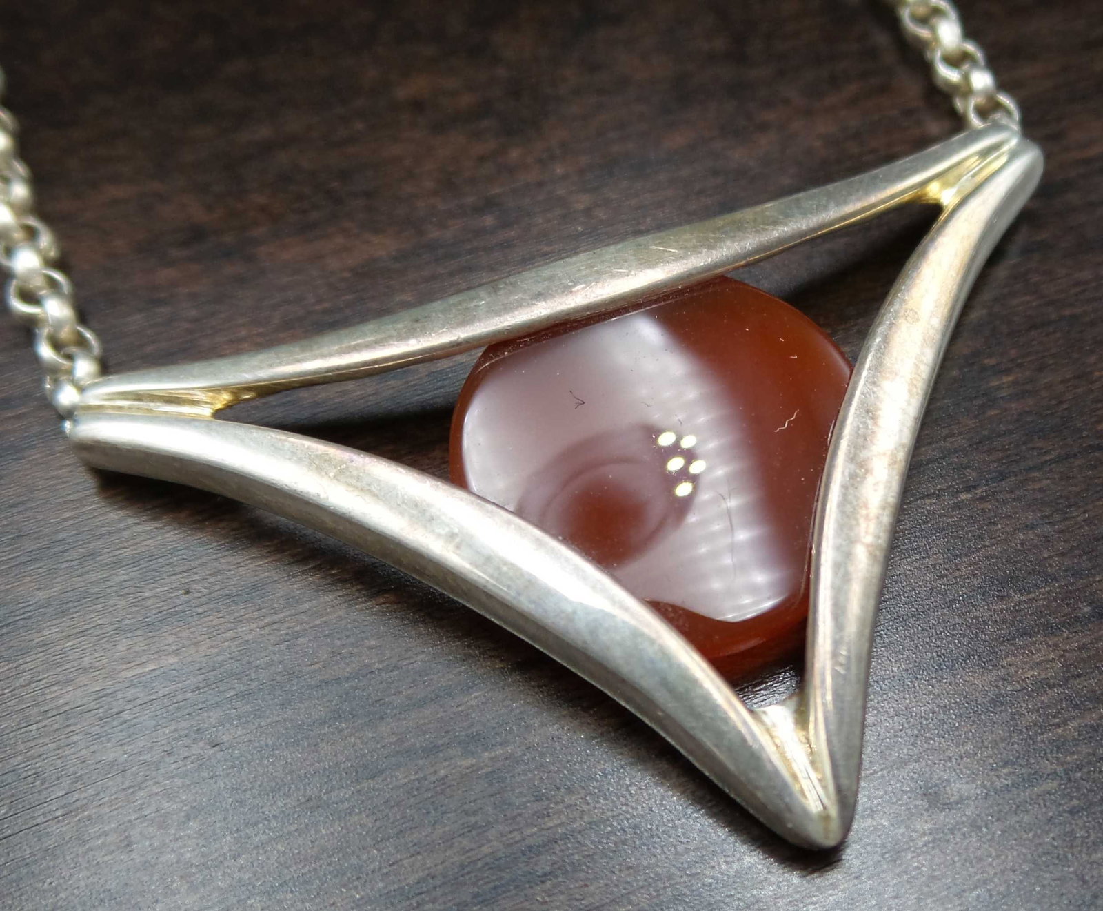 Vintage Mid-Century European Sterling Silver & Carnelian Designer Necklace: This gorgeous piece was made around the 1960s in Central Europe and features a red Carnelian disc set in a triangular Sterling Silver frame. The piece is in very good vintage condition, measures appro