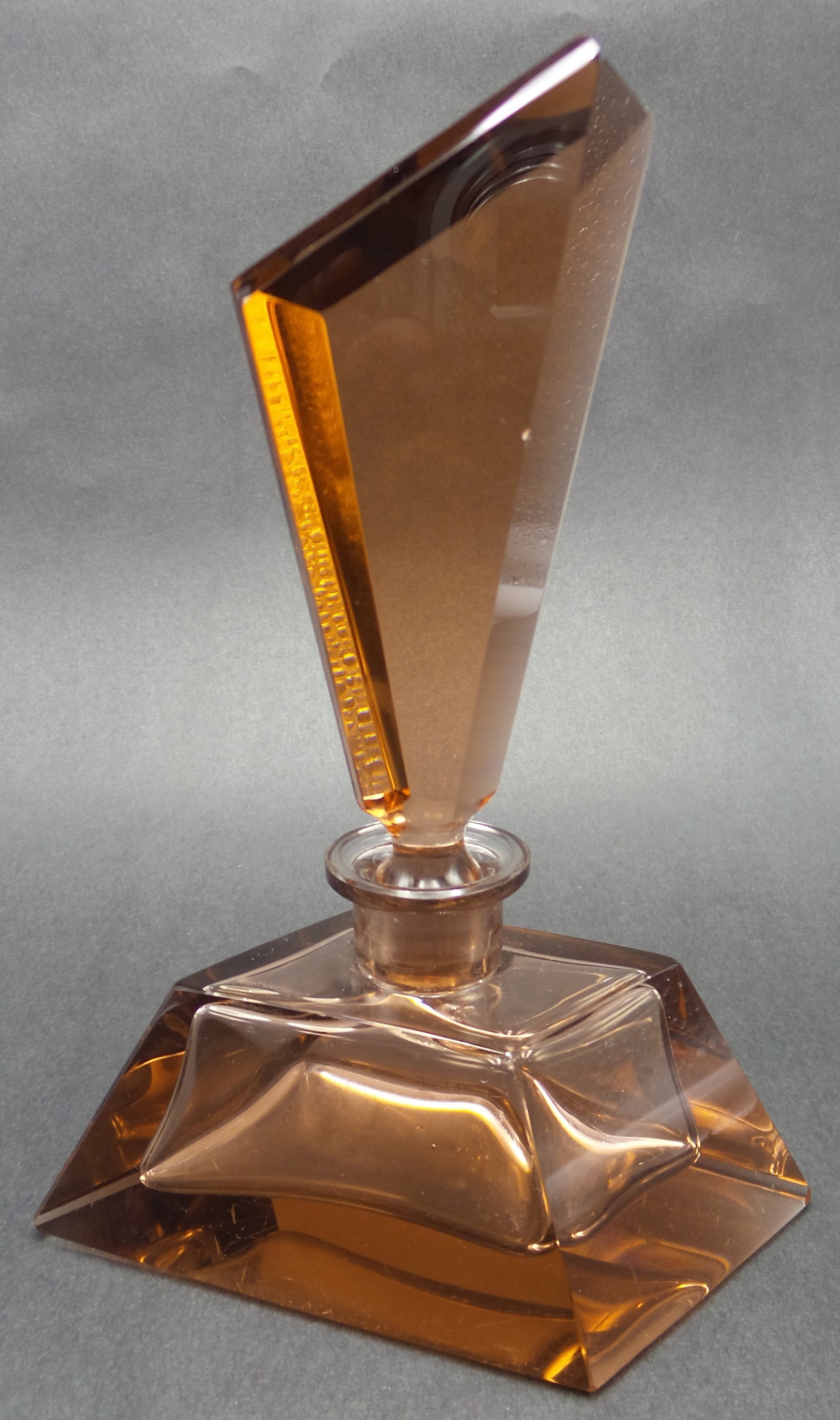 Antique European Art Deco Amber Glass Perfume Bottle: Measures approx. 6 1/2" tall with the base measuring approx. 4 7/8" x 2 1/8". Very good antique condition with minor wear according to age and one flea bite to the stopper. No chips, cracks, or repair