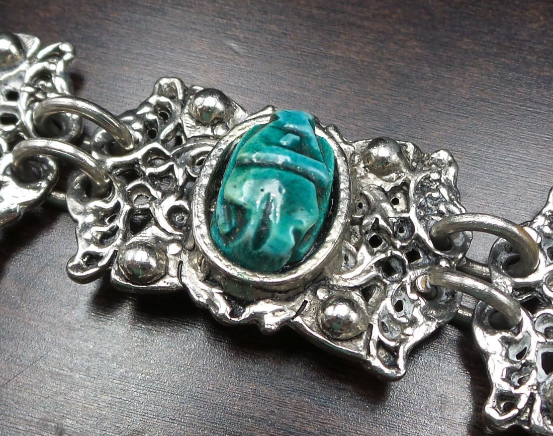 Vintage ca. 1940 European Costume Jewelry Egyptian Revival Scarab Bracelet: This beautiful piece was made around the 1940s in Europe and features 6 chrome plated metal panels of which 3 are adorned with green ceramic scarab beetles.The piece has a simple hook closure and meas