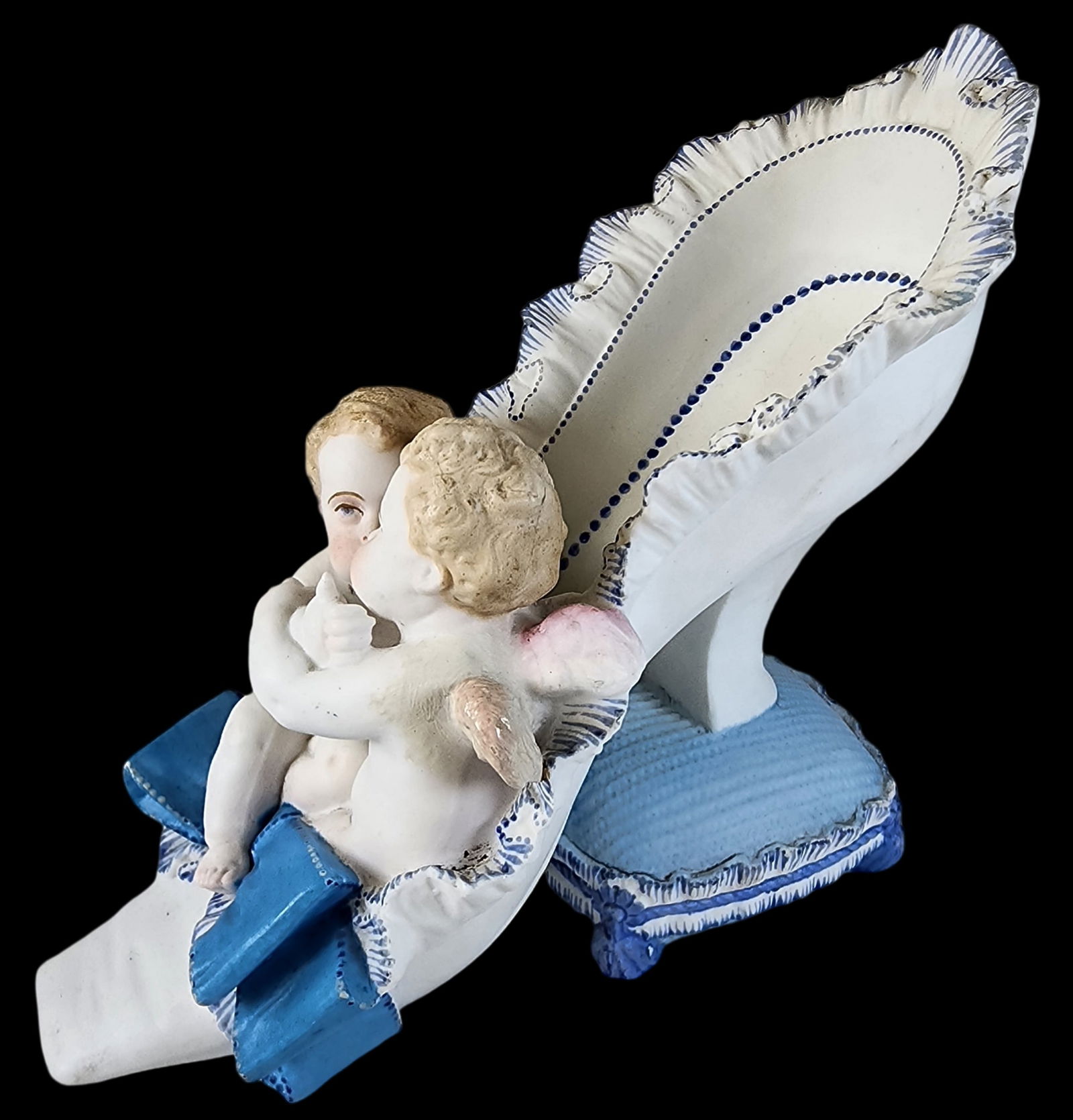 Antique MEISSEN Style Porcelain Model of a Ladies Heeled Slipper on Pillow: Beautiful piece made around the turn of the last century featuring frilled edges, bow to front with two embracing cherubs. Very good vintage condition; no chips, cracks, or repairs; minor wear and pai