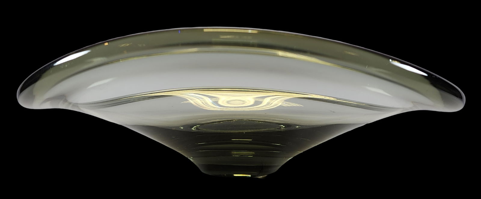 Large Mid-Century Modern Holmegaard Denmark Smoked Glass Curved Bowl: A mid-century smoked glass curved bowl by Holmegaard of Denmark. A flat base and circular form features curved wave-like rounded edges. Handblown in smoked grey glass with variances in color. Signed w