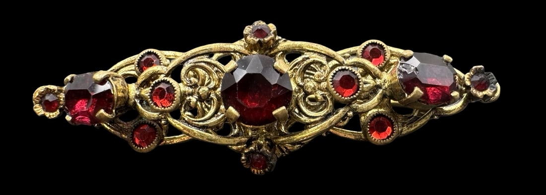 Ornate Vintage Costume Jewelry Gold Metal & Red Rhinestone Bar Brooch: Very good vintage condition with minor patina according to age. Measures approx. 2 1/4" long and 3/4" wide & weighs ca. 7.3 grams. SHIPPING: We ship in-house and charge a flat fee of $12 for any order