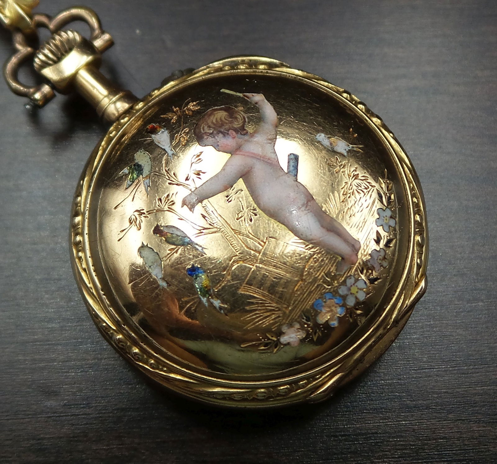 Rare Antique ca. 1900 18K Gold, Pearl & Enamel Putto Lapel Watch: This stunning piece features a lapel clip adorned with seed pearls and a masterfully enameled scene of a putto playing with birds. The white dial with blue Roman numerals and gold accents is just beau