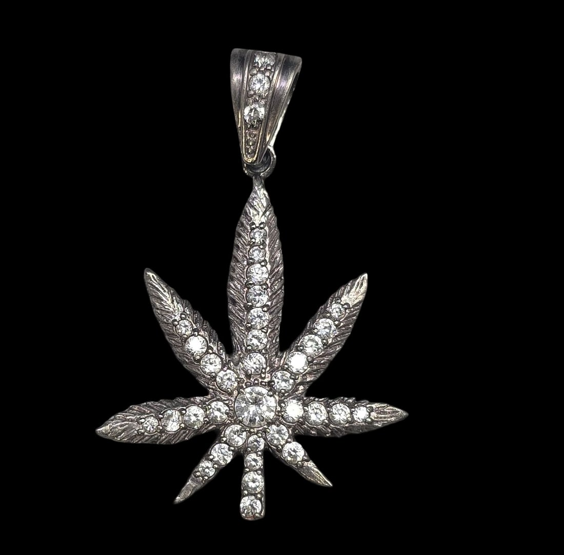 Unusual Vintage Sterling Silver & Rhinestone Weed/Cannabis/Marihuana Leaf Pendant: Very good vintage condition with minor patina and wear according to age. Measures approx. 2 1/2" high x 1 1/2" wide and weighs ca. 15 grams. Marked for Sterling Silver..
