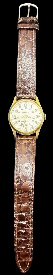 Vintage SHERATON Gold Tone & Brown Strap Watch: Very good vintage condition with minor patina according to age. Dial measures approx. 1" long and 1" wide and weighs ca. 26.92 grams. Marked for SHERATON. The timepiece is working and features an elas