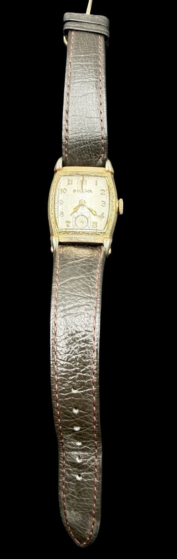 Vintage Mid-Century BULOVA Gold Filled & Brown Leather Strap Wristwatch: Very good vintage condition with minor patina according to age. Dial measures approx. 1" long and 3/4" wide and weighs ca. 23.69 grams. Marked for BULOVA. The timepiece is currently not working.